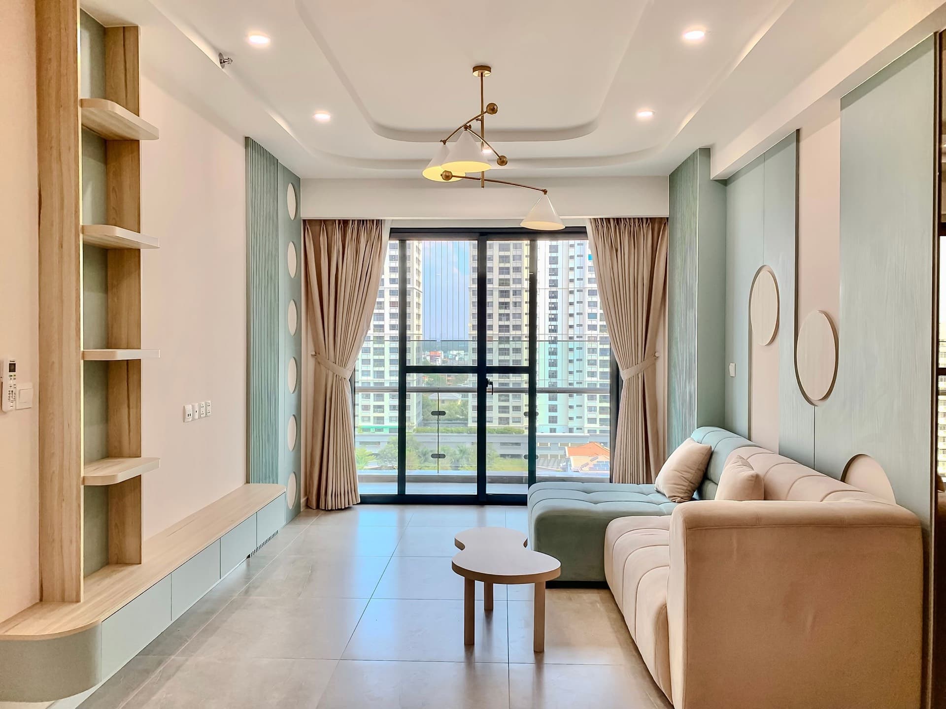 Sala luminosa de un apartamento urbano con ventanales y vista a la ciudad